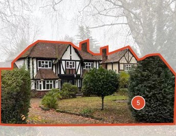 Detached house surrounded by a curated garden with low edging.