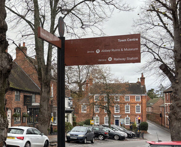 The signpost points to the Town Centre, Abbey Ruins & Museum, and Railway Station.